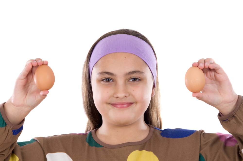 Adorable girl with two eggs on his hands